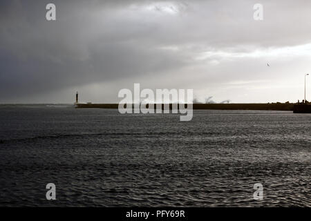 Moody ampia vista della voce del romantico fiume Ave, Portogallo, Vila do Conde (vicino al porto), poco prima del tramonto vedendo alcuni onde tempestose contro paglierino Foto Stock