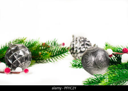 Natale rami di abete con diversa decorazione come sfere di scarlatto, pigne. Su sfondo bianco. Foto Stock