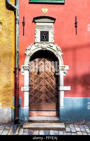 Un ornato porta di legno di una casa rossa in Gamla Stan (Citta vecchia), Stoccolma, Svezia Foto Stock