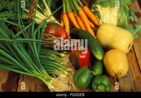 Raccolto un assortimento di verdure fresche sul tavolo di legno (cipolline, cavolfiore, carote, peperoni rossi, cetriolo e spinaci. Foto Stock