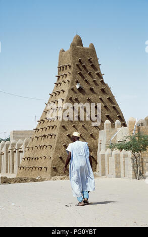 Uomo in vesti bianche a camminare verso la moschea di Sankore in Timbuktu, Mali per solo uso editoriale Foto Stock