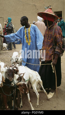 Capre e pastori al lunedì mercato alla Grande Moschea di Djenne, Mali per solo uso editoriale Foto Stock