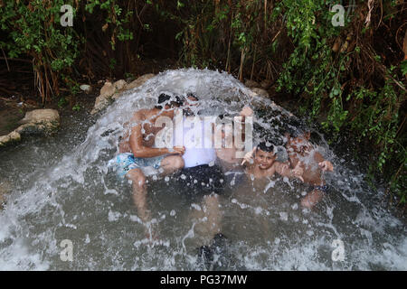 La famiglia palestinese di Hebron gode di una sorgente d'acqua a Ein Feshka, nota anche come riserva naturale Einot Tzukim, sulla riva settentrionale del Mar Morto in Israele. Migliaia di palestinesi della Cisgiordania hanno attraversato i checkpoint israeliani e hanno visitato i siti intorno a Israele durante le vacanze di Eid al-adha. Foto Stock