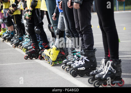 Vista ravvicinata delle ruote prima di pattinaggio.gambe in rollskikovye pattini sono allineate in una fila Foto Stock