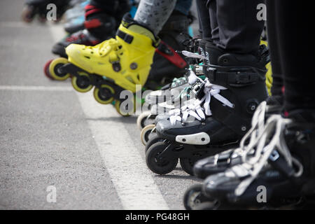 Vista ravvicinata delle ruote prima di pattinaggio.gambe in rollskikovye pattini sono allineate in una fila Foto Stock