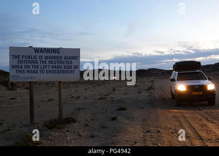 Auto 4x4 passando da un segnale di avvertimento di area riservata, Namibia Foto Stock