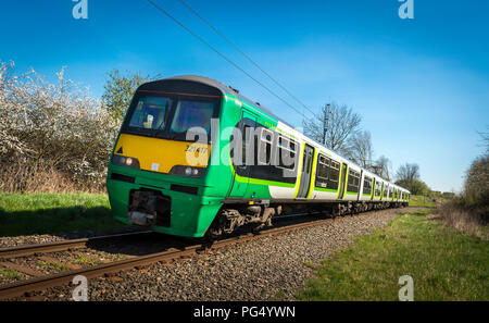 Classe 321 treni passeggeri in London Midland livrea che viaggia lungo la via sulla linea di Abbazia, Inghilterra. Foto Stock