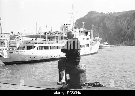 Il scrittore ceco Bohumil Hrabal siede su un bollard nel porto dell'isola italiana di Capri. Foto Stock