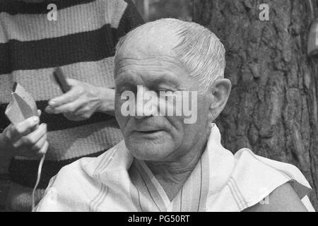 Il scrittore ceco Bohumil Hrabal ottiene il suo taglio di capelli nel giardino della sua casa estiva di Kersko vicino a Praga. Foto Stock