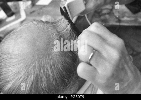 Il scrittore ceco Bohumil Hrabal ottiene il suo taglio di capelli nel giardino della sua casa estiva di Kersko vicino a Praga. Foto Stock