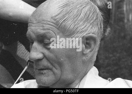Il scrittore ceco Bohumil Hrabal ottiene il suo taglio di capelli nel giardino della sua casa estiva di Kersko vicino a Praga. Foto Stock