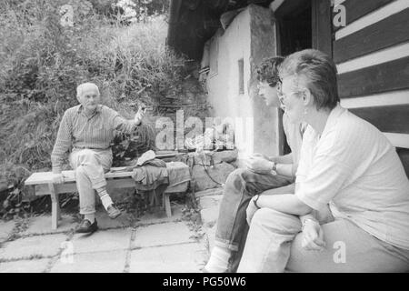 Lo scrittore Bohumil Hrabal su un banco di fronte alla casa del pittore Josef Jira. Proprio di fronte è il traduttore Susanna Roth. Foto Stock