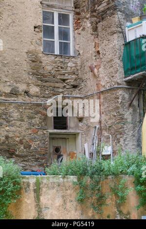 Vecchia casa di mattoni rovina con un piccolo giardino Foto Stock