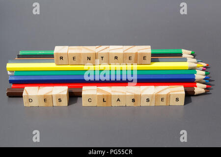 Si torna a scuola scritto in lingua francese e matite colorate su sfondo grigio Foto Stock