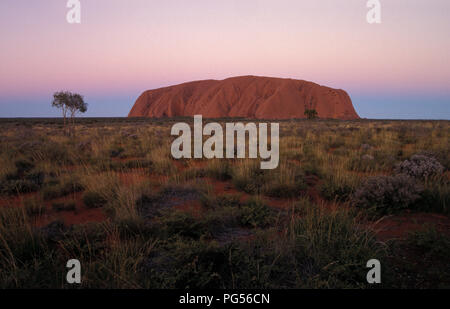 Uluru Ayers Rock nel cuore del territorio del nord del centro rosso deserto è considerato uno dell'Australia che le principali attrazioni turistiche. Foto Stock