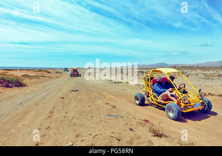 Quads guidare oltre le aride polveroso tracciato costiero da Caleta de Fuste a Salinas del Carmen in Fuerteventura, Spagna Foto Stock