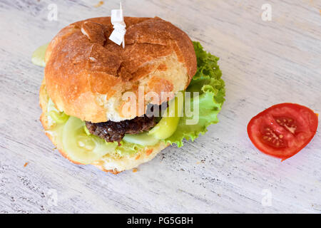 Il fast food/ Hamburger in burger bun whit un chop, cetriolo, lattuga e pomodoro/ gustoso sandwich per il pranzo Foto Stock