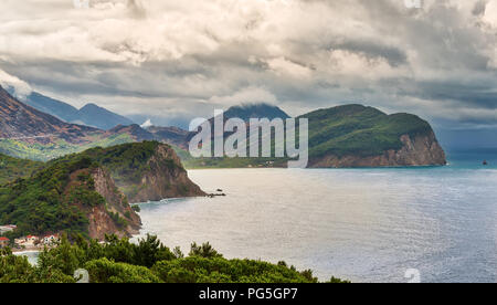 Vista panoramica della costa e del paesaggio di montagna vicino a Petrovac la città e il mare Adriatico nella luce del mattino con cielo nuvoloso, Montenegro, Europa Foto Stock