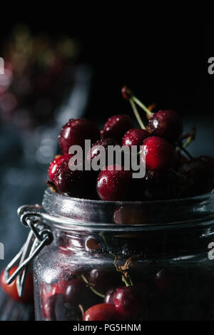 Vista ravvicinata di ripe wet ciliegie dolci in un barattolo di vetro Foto Stock