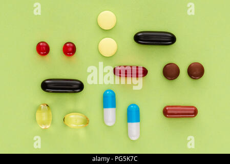 Vista superiore della disposte varie pillole su sfondo verde Foto Stock
