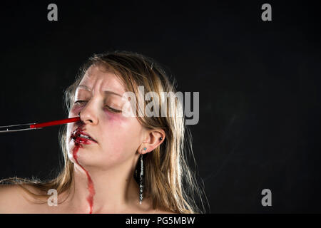 Plastica nell'Oceano orrore pezzo - Sangue / Gore / paglia di plastica fino a una ragazza del naso Foto Stock