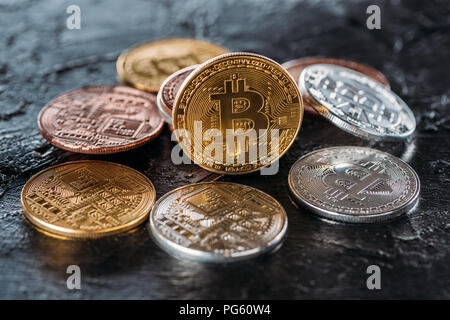 Vista ravvicinata di vari bitcoins sulla superficie scura Foto Stock