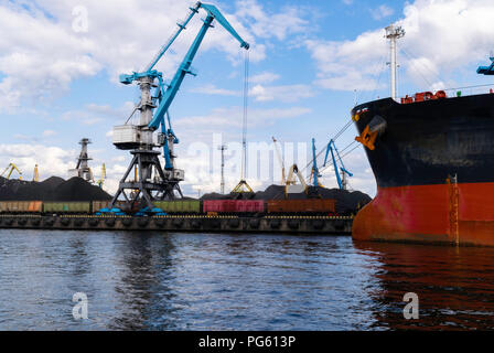 Rosso grande nave cargo carico con un carbone nel porto, terminale, gru, contenitore Foto Stock
