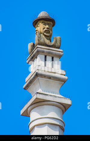 Una moderna statua di un il volto dell'uomo su un alto in pietra sulla colonna il municipio in stile rinascimentale di Poznan (Poznan), Polonia Foto Stock