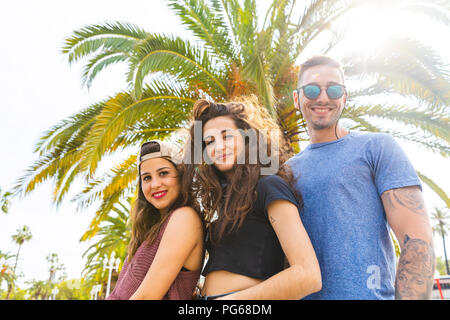 Ritratto di sorridere i tuoi amici a Palm tree Foto Stock