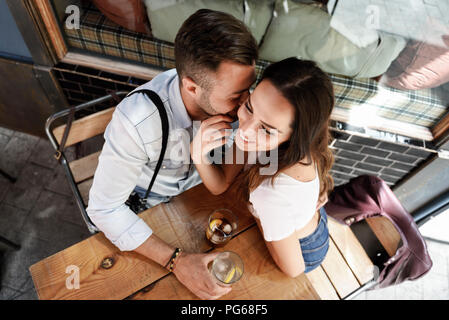 Affettuosa giovane avente un drink in un bar all'aperto nella città Foto Stock