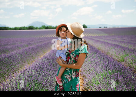 Francia, Provenza, altopiano di Valensole, Madre baciare la figlia in campi di lavanda in estate Foto Stock