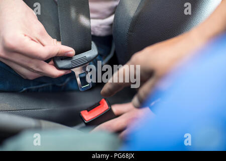 Mani maschili in auto di fissaggio cintura di sicurezza Foto Stock