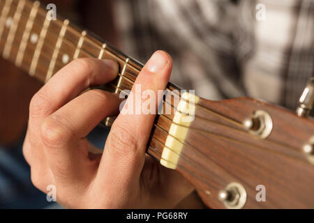 Close-up di mano d'uomo a suonare la chitarra Foto Stock