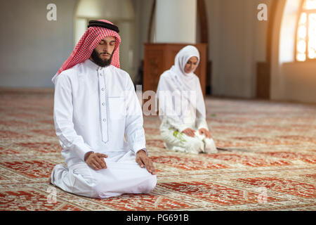 Musulmani l uomo e la donna che prega in moschea Foto Stock