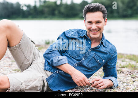 Ritratto di uomo sorridente di relax presso il Riverside Foto Stock
