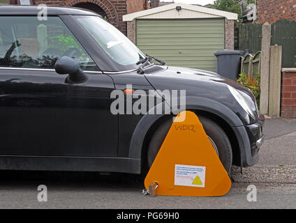 Orange DVLA morsetto, immobilizzando un black mini veicolo, dove UK auto tassa non è stata pagata, Grappenhall, Warrington, Cheshire, North West England, Regno Unito Foto Stock