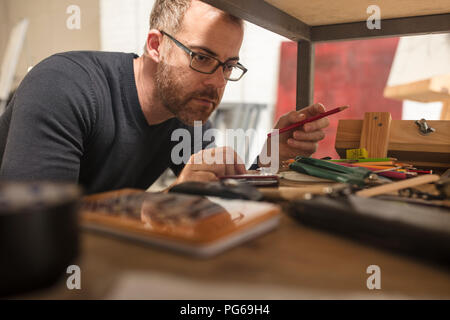 Uomo in artist's studio il controllo dei materiali di consumo Foto Stock