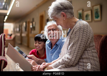 Insegnamento infermiere gli anziani nella casa di riposo, come utilizzare il computer portatile Foto Stock