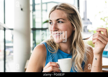 Giovane donna in cafe di bere il caffè Foto Stock