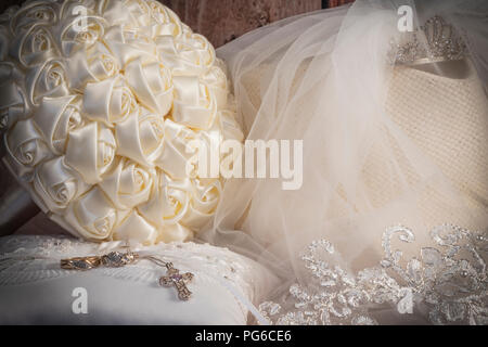 Sposa bouquet con tiara & velo bianco occidentale hat, gli anelli di nozze & croce sul ring del portatore cuscino Foto Stock