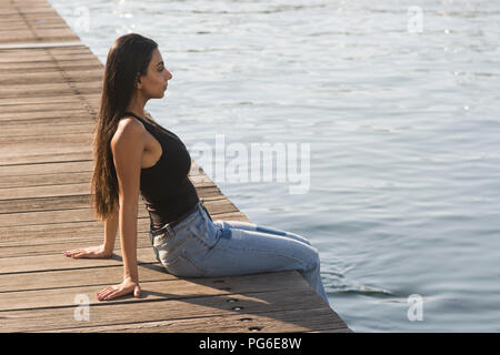 Giovane donna sat sul molo dal mare Mediterraneo Beirut Foto Stock