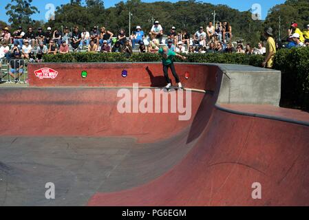 Lo skateboard sport in Australia, Coffs Harbour il 18 agosto 2018. Ragazzo guidatore di skateboard che mostra le sue abilità mentre gli spettatori guarda. Foto Stock