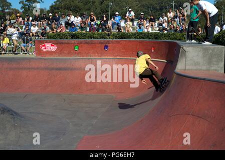 Lo skateboard sport in Australia, Coffs Harbour il 18 agosto 2018. Ragazzo guidatore di skateboard che mostra le sue abilità mentre gli spettatori guarda. Foto Stock