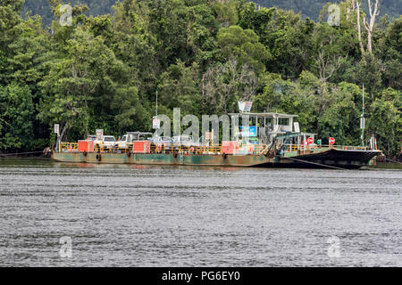 Ferry crossing Daintree river against mist covered mountain Foto Stock