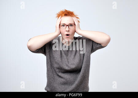 Wow. Bella donna caucasica con capelli rossi isolato su grigio studio backgroud. Foto Stock