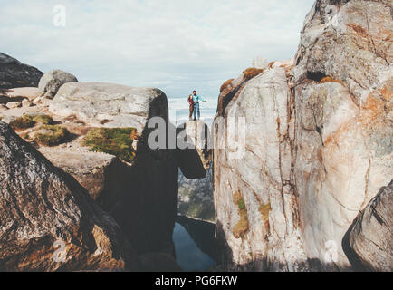 Giovane turisti su Kjeragbolten viaggiando in Norvegia Kjerag montagna Vacanze Avventura famiglia lifestyle l uomo e la donna insieme permanente sulla scommessa di pietra Foto Stock
