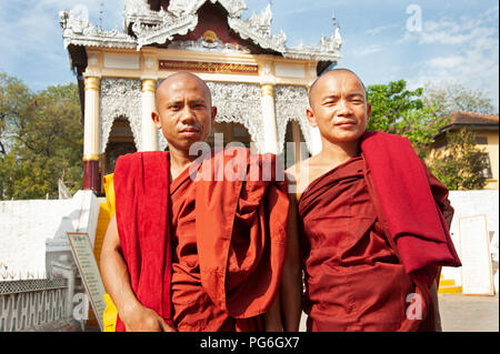 Due monaci buddisti in piedi di fronte ad un enorme pagoda entrata a Mandalay Hill le fasi che portano alla sommità del Mandalay Hill Myanmar Foto Stock