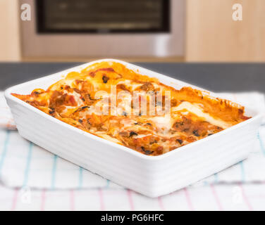 Una Lasagna Vegetariana appena fuori la ovan e pronti per il taglio. Impostare la messa a fuoco davanti al centro e si ammorbidisce verso la parte posteriore del piatto. Foto Stock