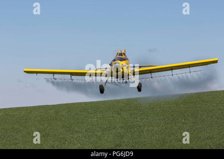 Crop duster piano di volo e la spruzzatura su colture nella regione Palouse dello stato di Washington Foto Stock