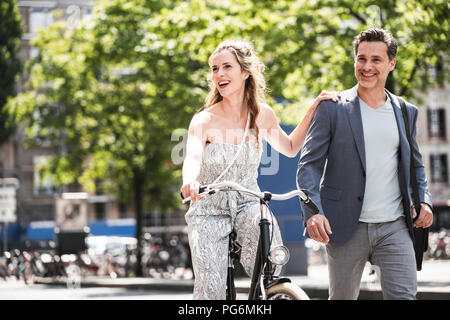 Coppia felice con la bicicletta in città Foto Stock